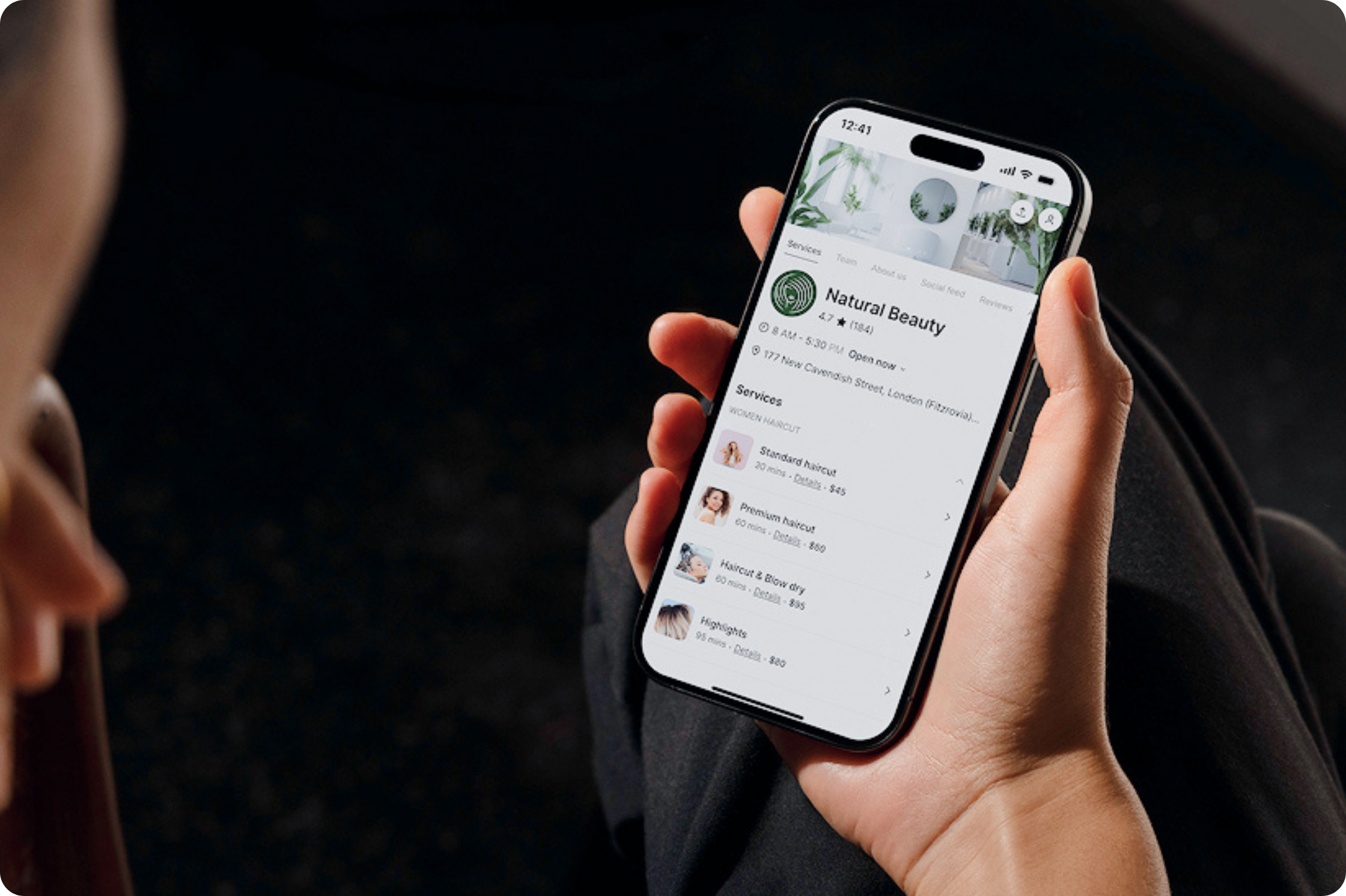 hand holding phone, setmore booking page on screen