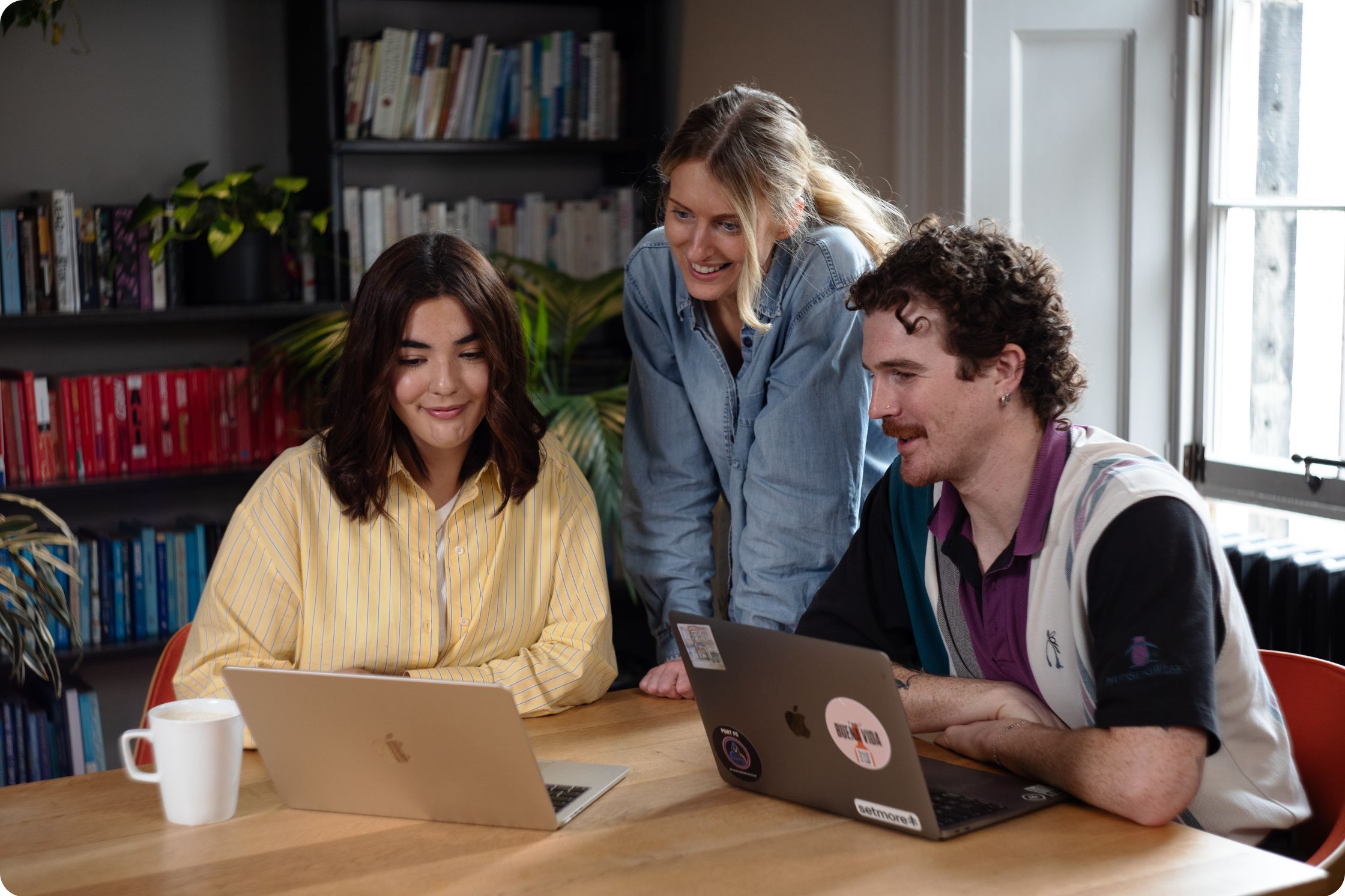 a group of three people, looking at the same laptop