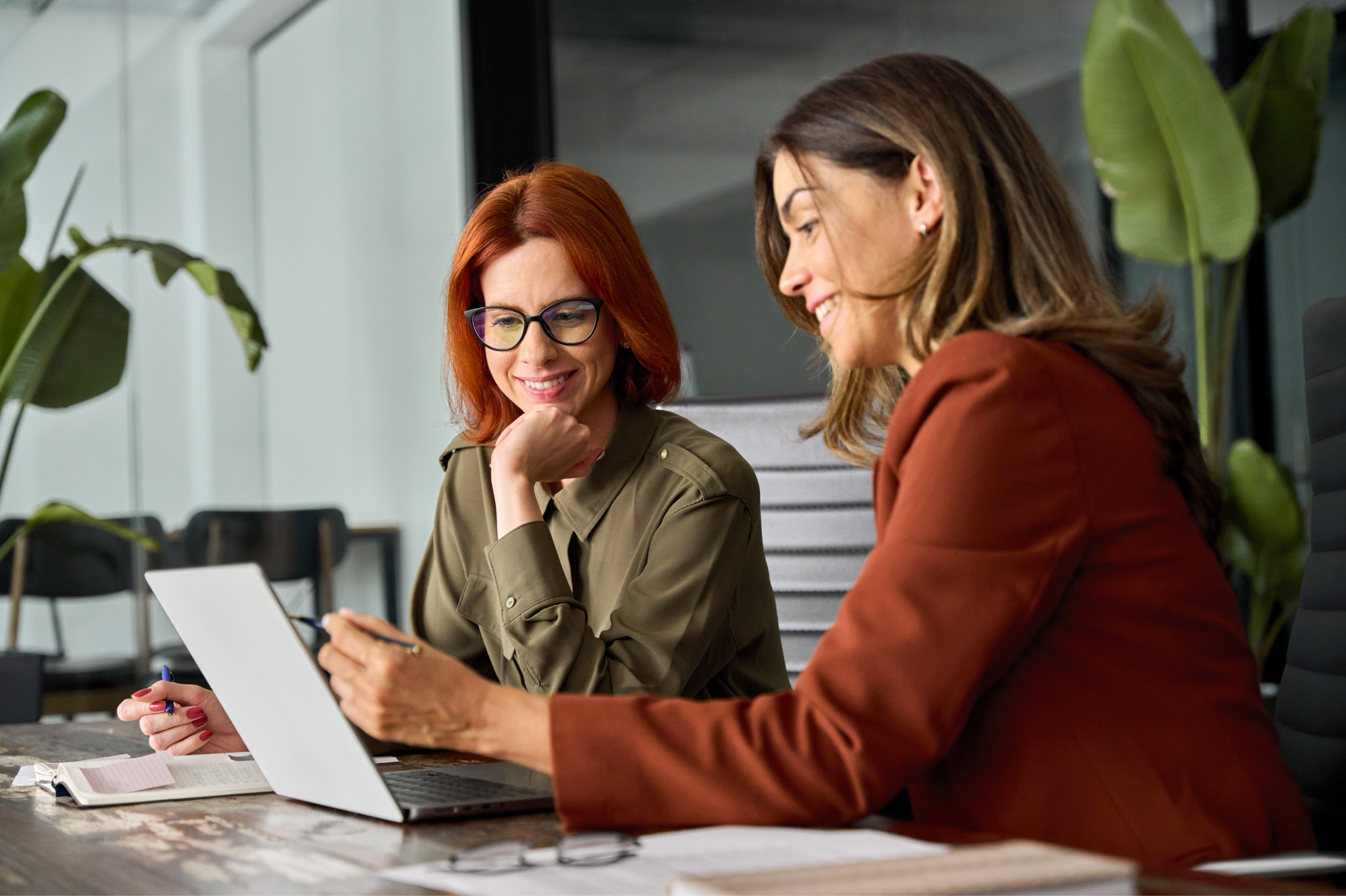 two woman, looking at laptop
