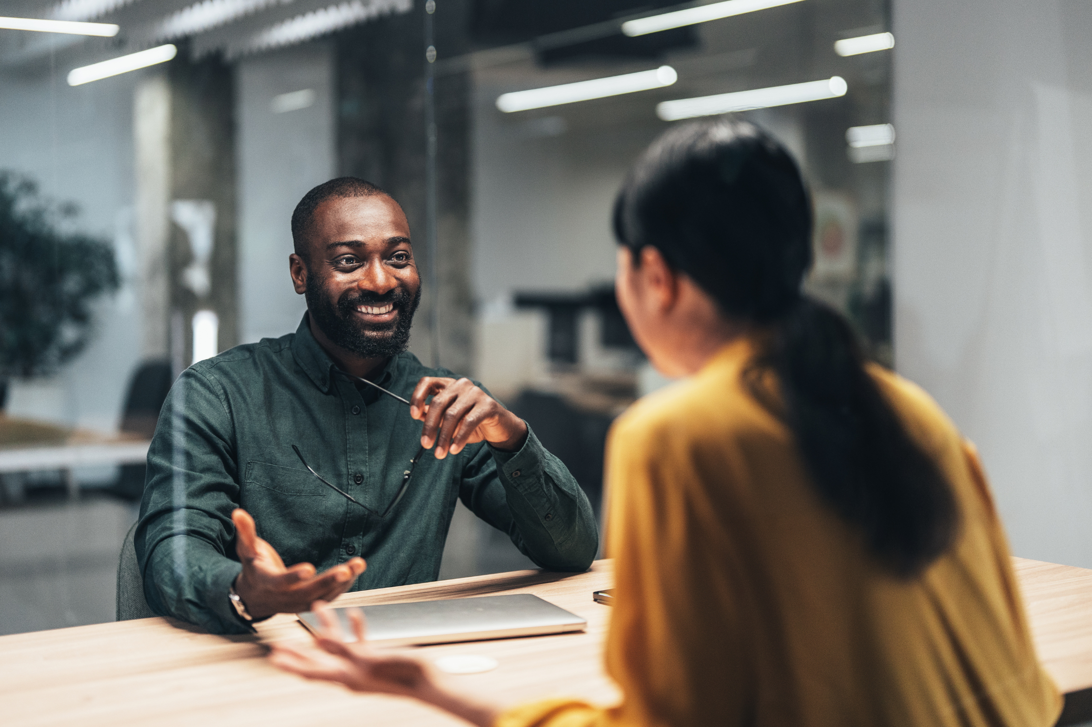 man and woman talking at desk