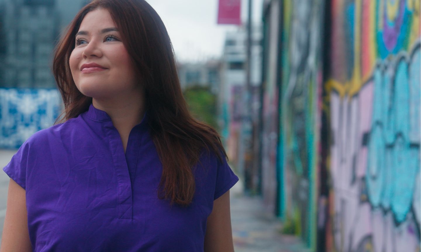 woman wearing purple top, walking down street