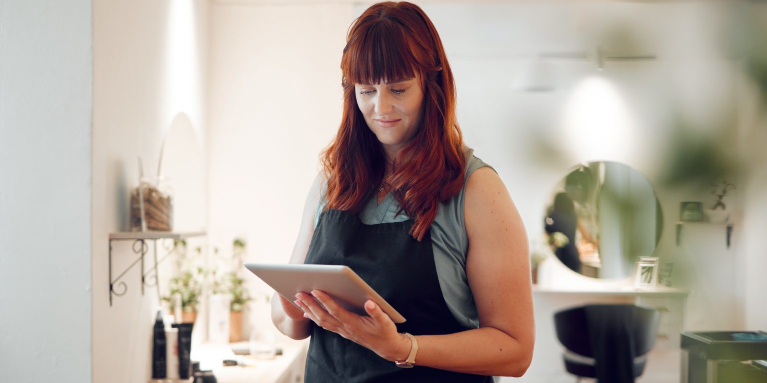 Lady looking at a ipad in apron
