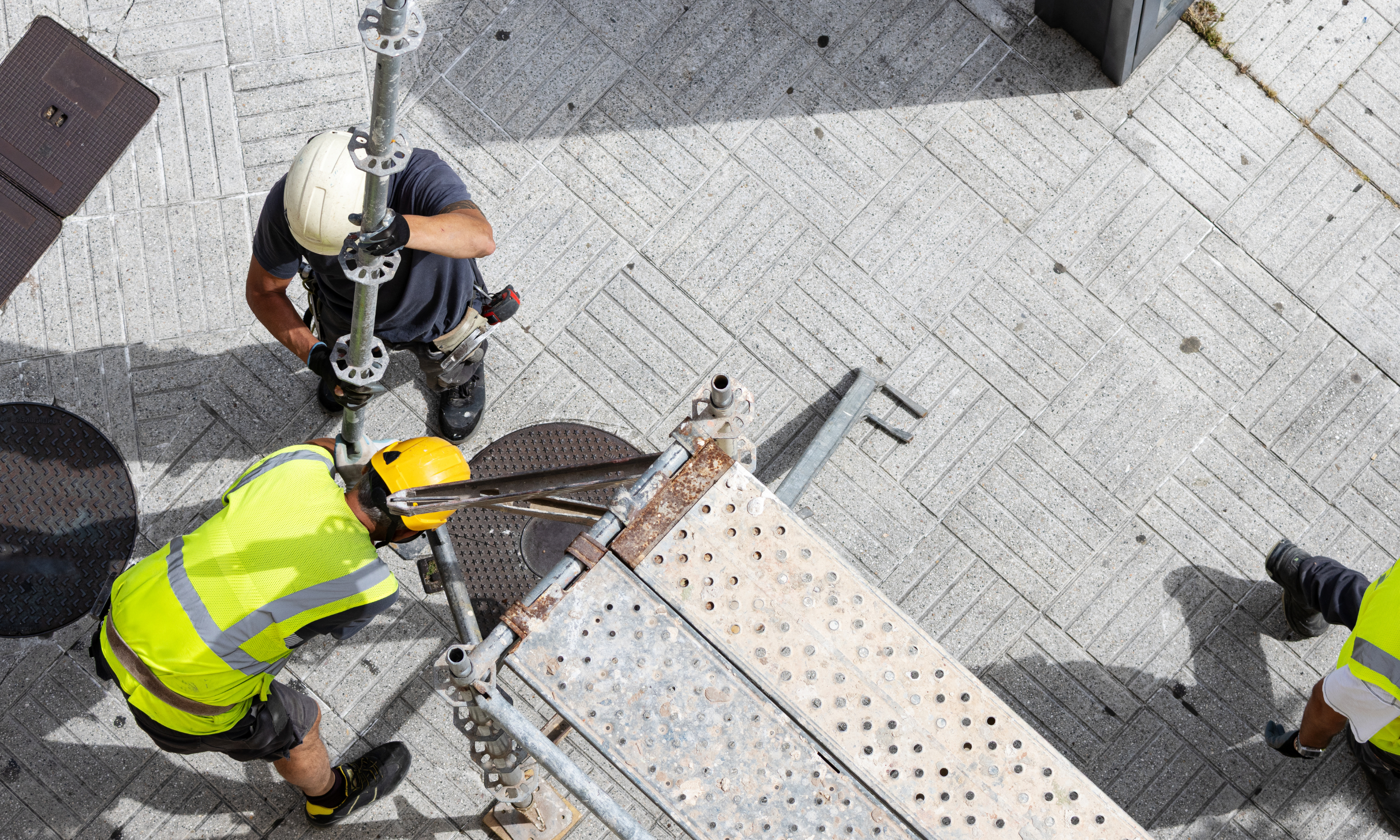 two men in high-vis jacket, fitting scaffolding
