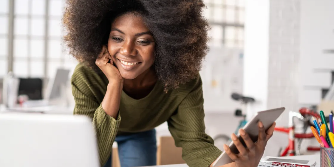 Smiling Lady looking at a Mac Book
